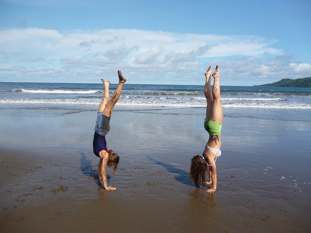 chicas practicando gimnasia acrobática en la playa (acrosport)